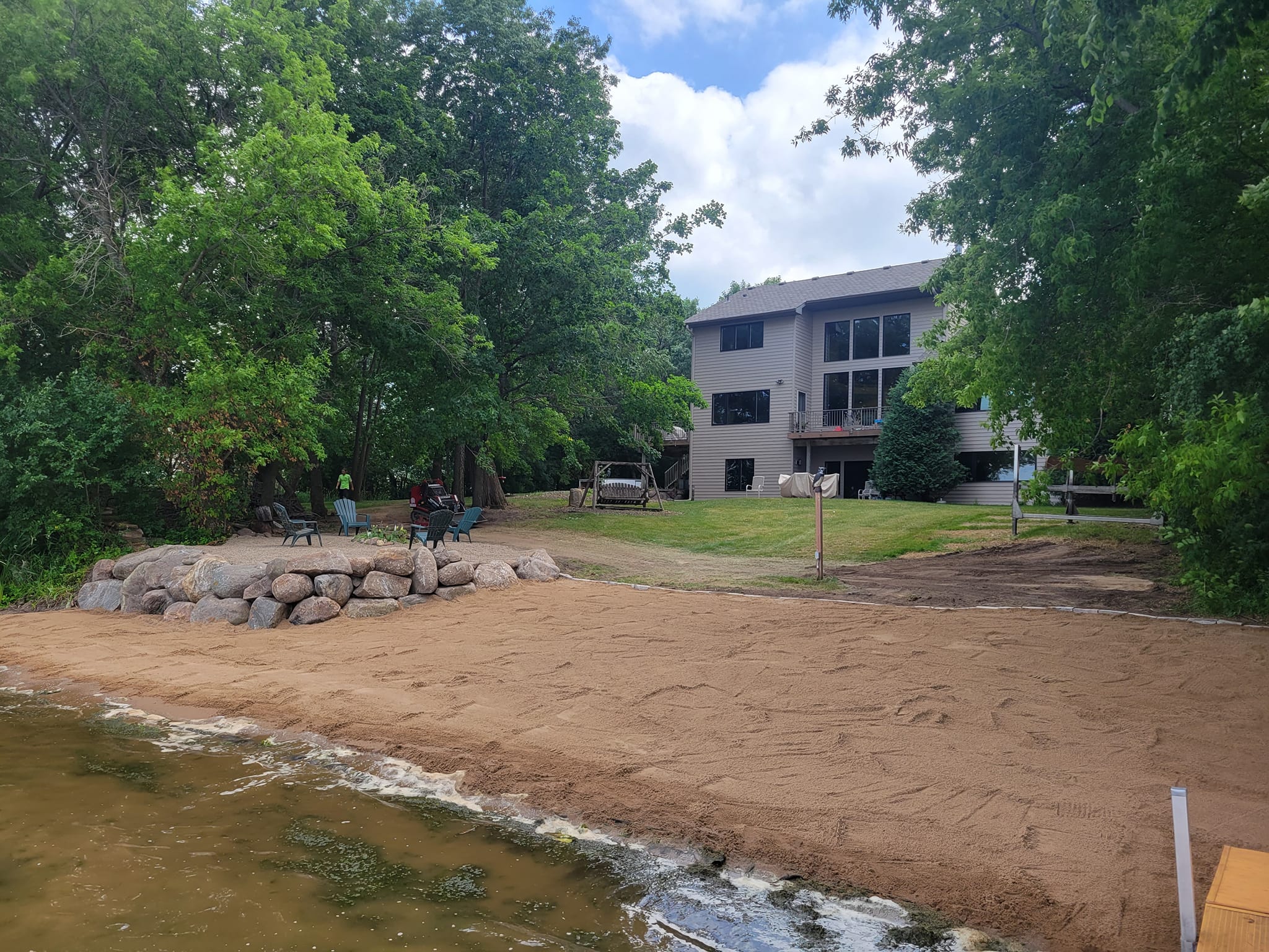 Restored lakeshore with sandy beach and trees